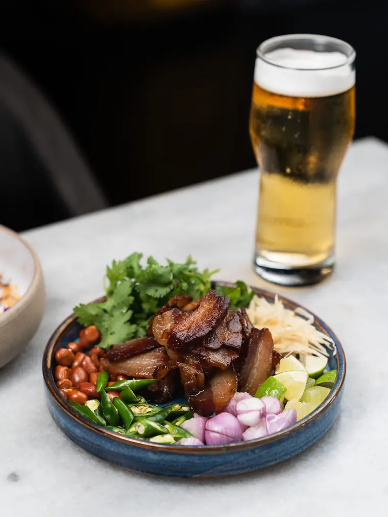 Grilled pork with fresh herbs, peanuts and shallots, and a cold beer.