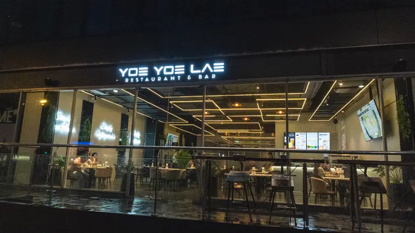 Yoe Yoe Lae Phra Khanong at night: diners inside a glass frontage at Summer Hub.